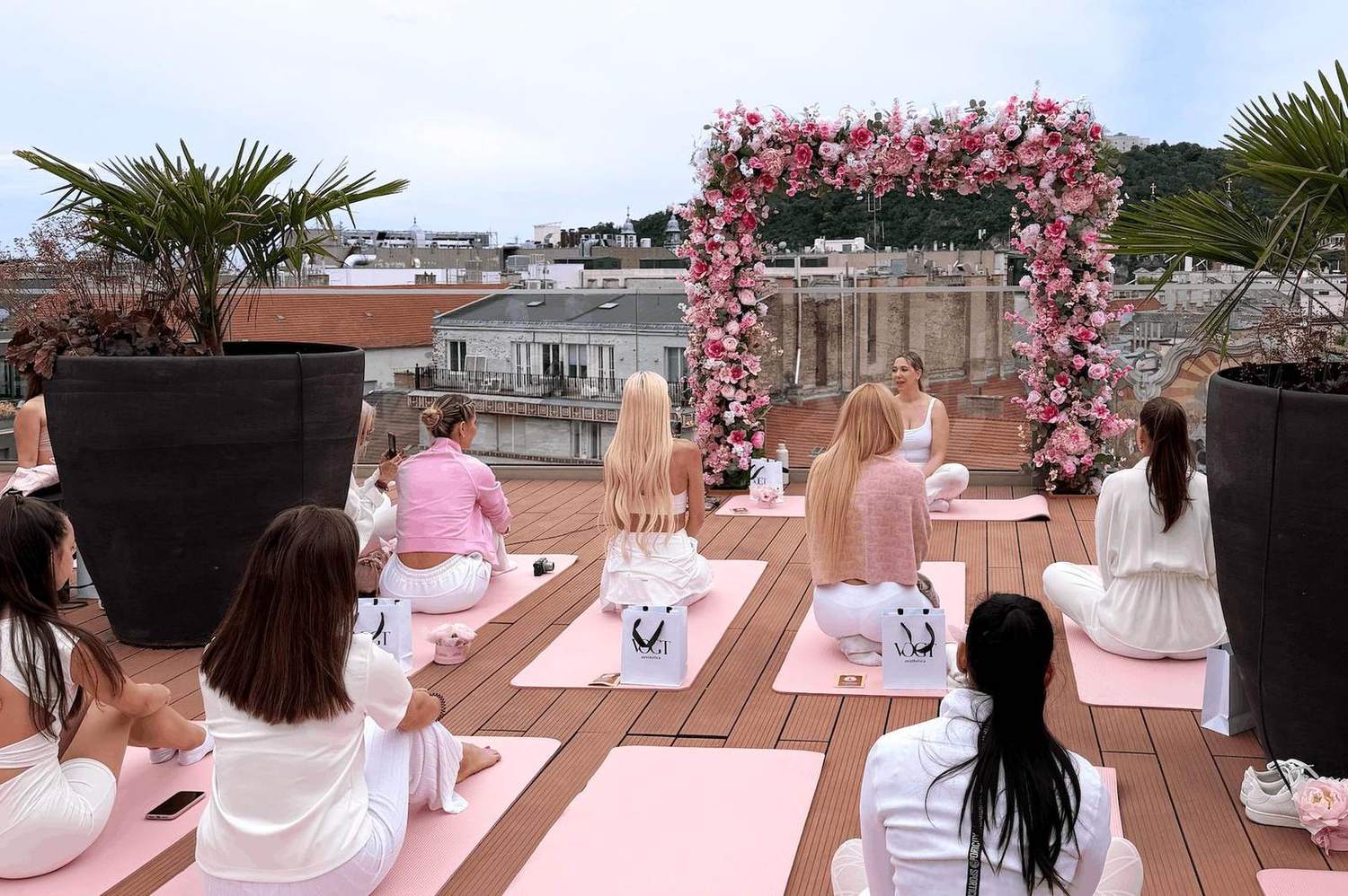 Soluna Kakaozeremonie auf einer Dachterrasse mit Blumenbogen und rosa Yogamatten